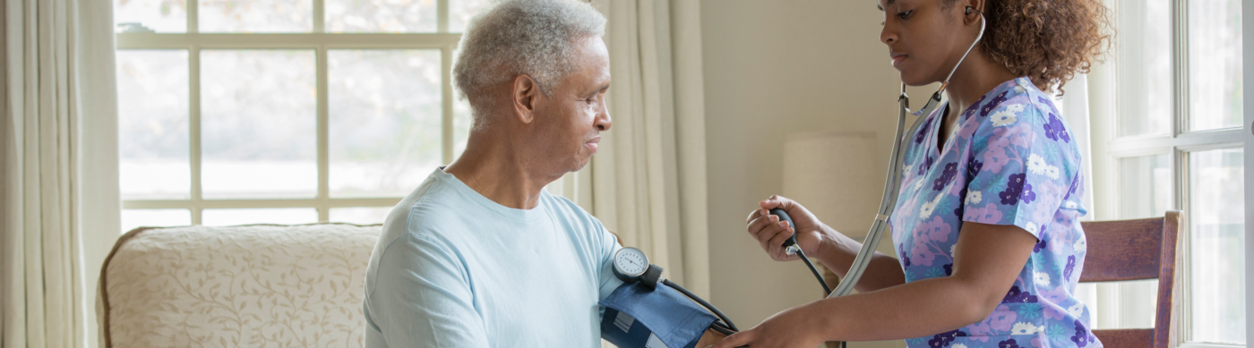 Young female nurse taking mans blood pressure