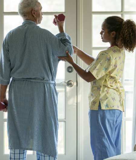 Young nurse helping older man with physical therapy