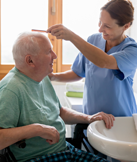 Female nurse combing older man's hair