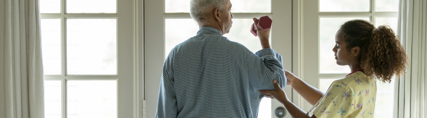 Young nurse helping older man with physical therapy