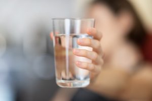 hand holding glass of water