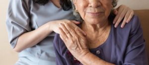 caregiver hand on elderly paitient's shoulder