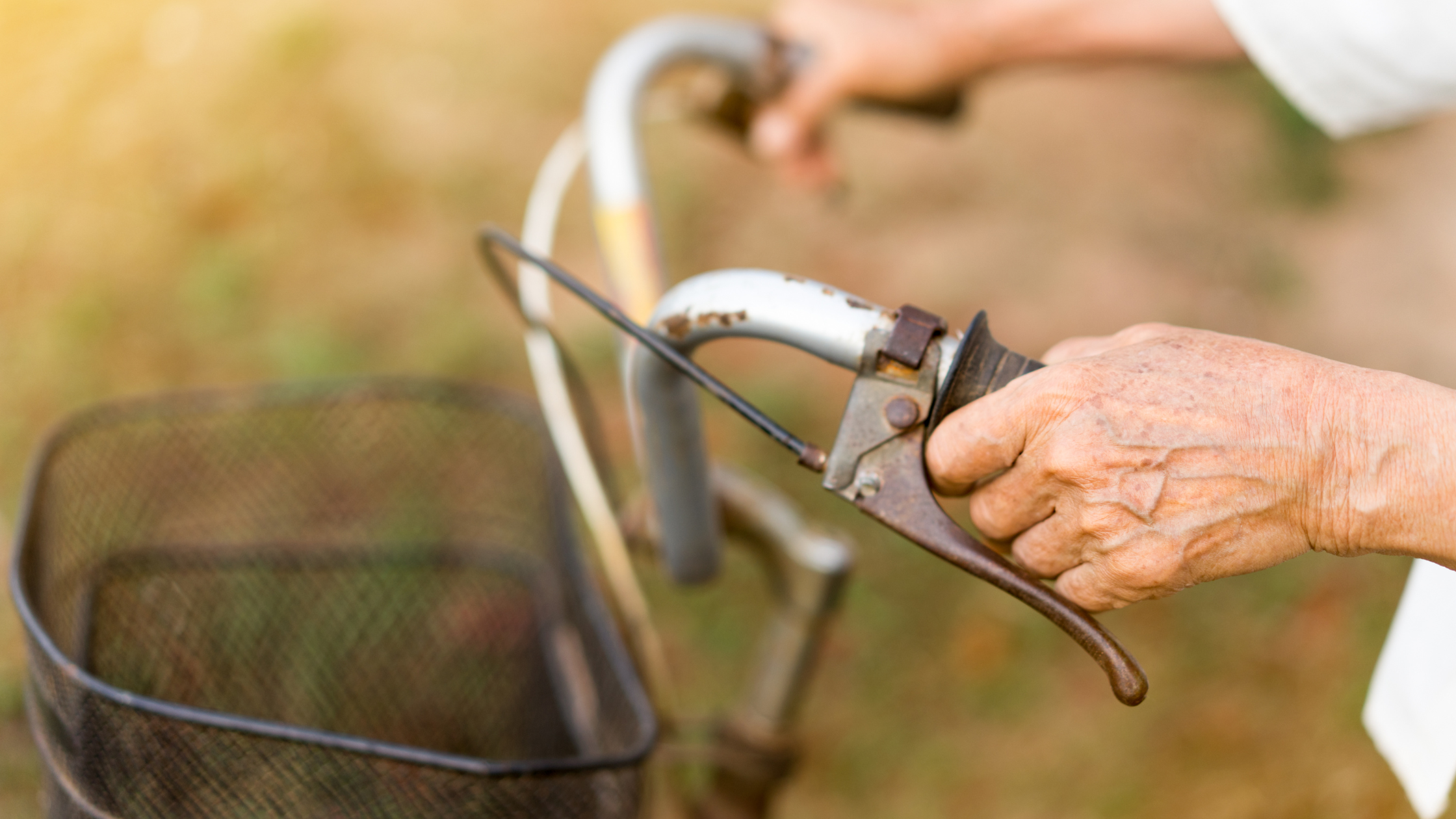 elderly hands holding bicycle handlebars
